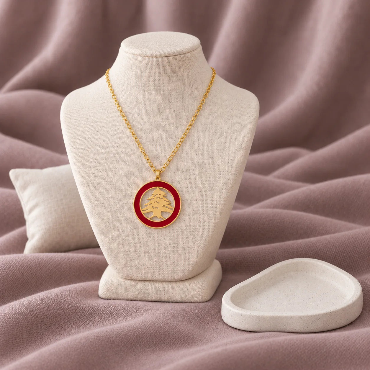 Arz Red Enamel Necklace — on ivory display with mauve fabric and white styling props