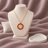 Arz Red Enamel Necklace — on ivory display with mauve fabric and white styling props