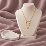 Lebanon Map Necklace — on ivory display with mauve fabric and white styling props