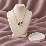 White Shaffe Coffee Cup Necklace — on ivory display with mauve fabric and white styling props