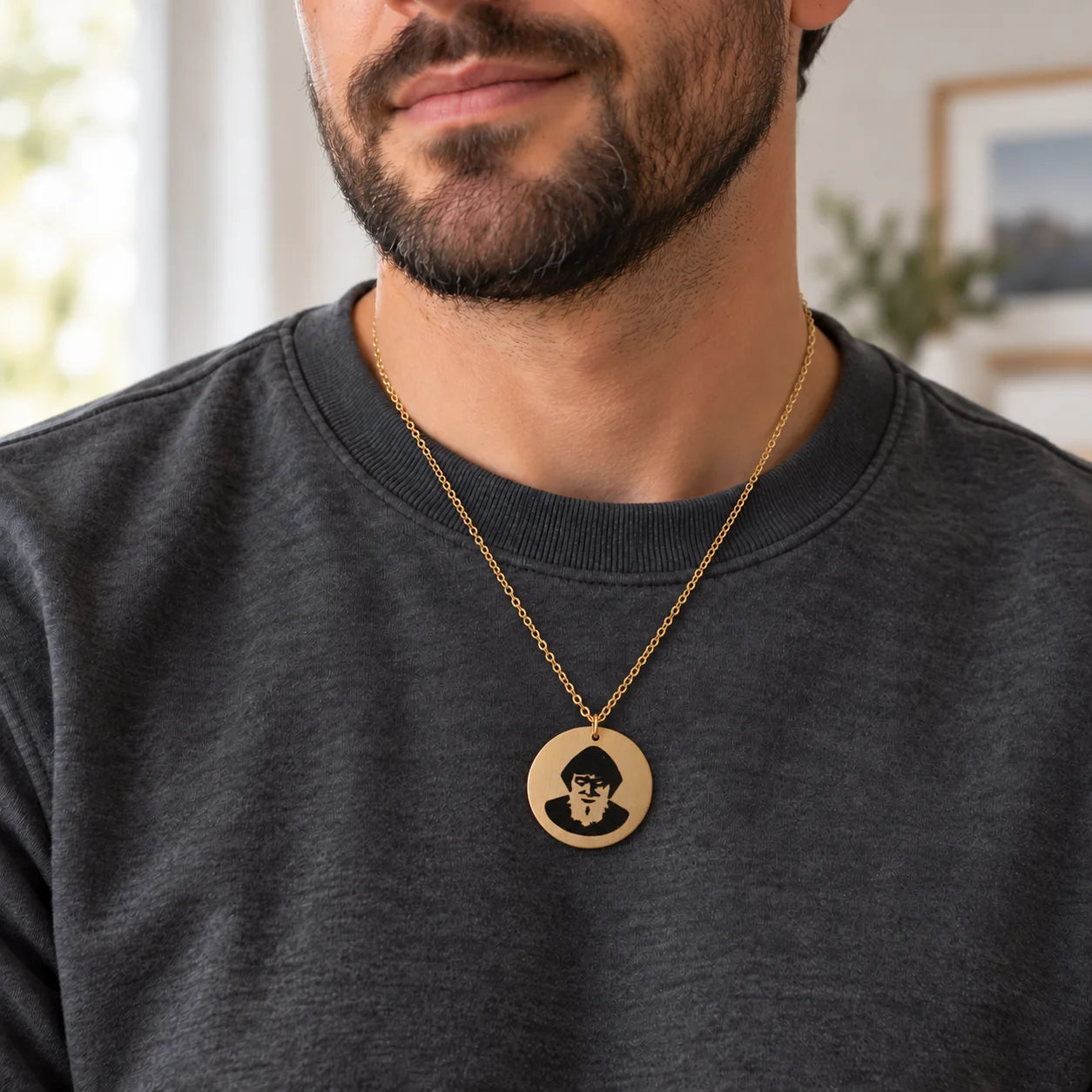 St. Charbel necklace worn over a man’s charcoal sweatshirt.