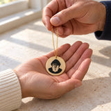 A St. Charbel necklace being placed in someone’s open hand.