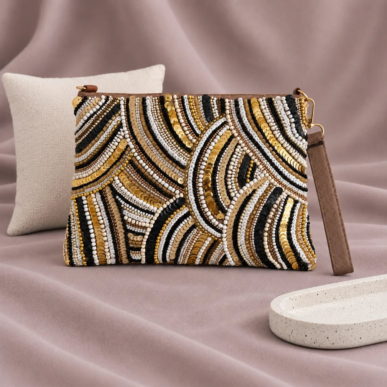 Zeina Beaded Clutch standing upright on muted mauve fabric with visible minimal white styling props