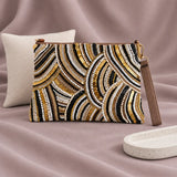 Zeina Beaded Clutch standing upright on muted mauve fabric with visible minimal white styling props