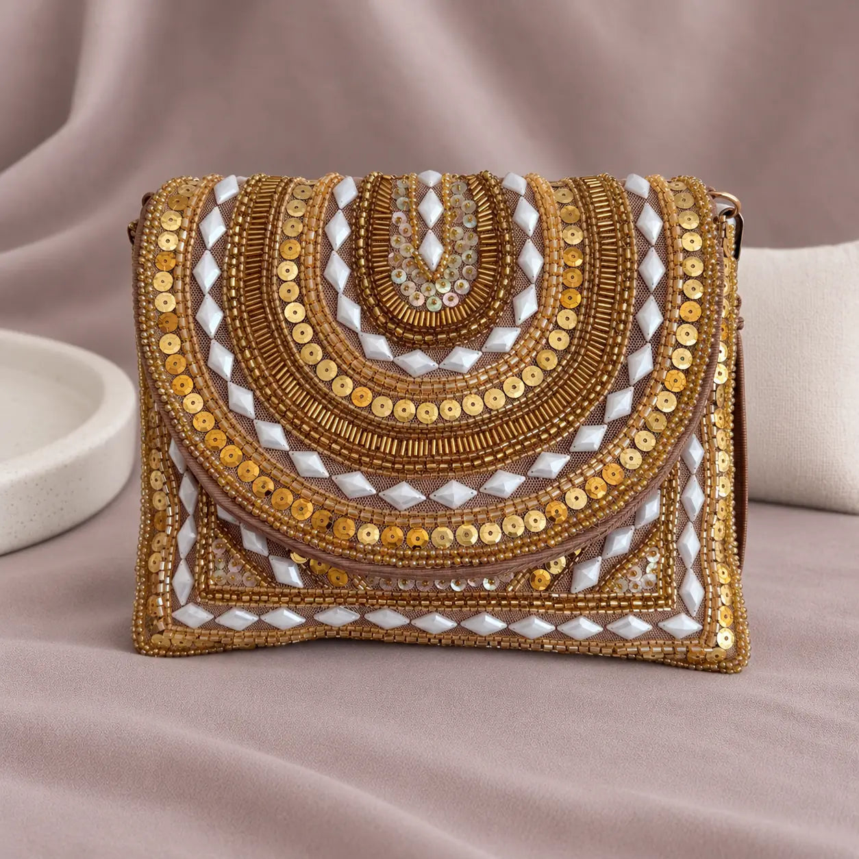 Ruby Beaded Clutch standing upright on muted mauve fabric with visible minimal white styling props