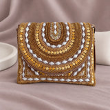 Ruby Beaded Clutch standing upright on muted mauve fabric with visible minimal white styling props