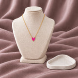 Pink Heart Enamel Necklace — on an ivory display with mauve fabric and white styling props