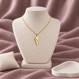Arabic Initial Enamel Necklace — on an ivory display with mauve fabric and white styling props
