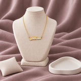 Set El Kel Enamel Necklace — on an ivory display with mauve fabric and white styling props